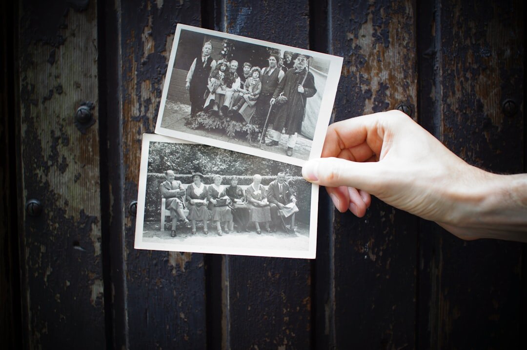 Close-up of elderly hands holding an old black and white family photograph
